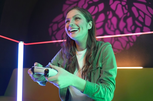 Medium shot smiley woman playing videogame