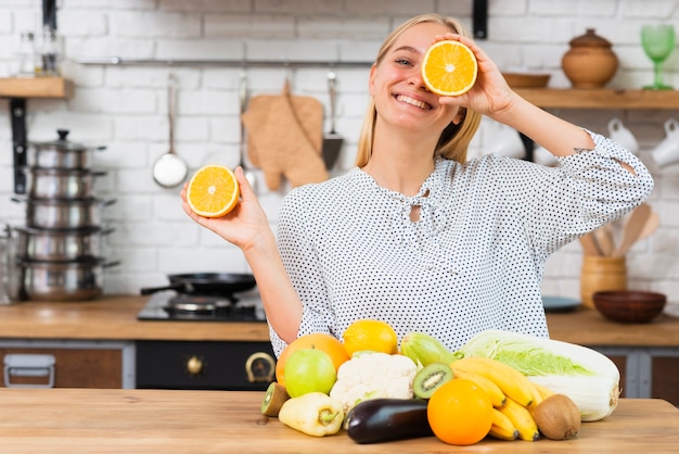 Medium shot smiley woman playing with oranges