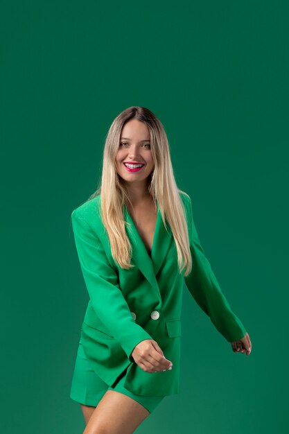 Улыбающаяся женщина среднего кадра позирует в зеленом наряде