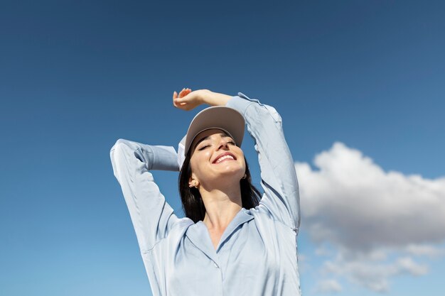 Medium shot smiley woman posing with hat