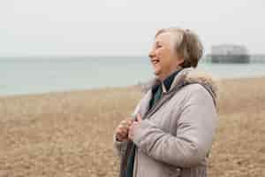 Free photo medium shot smiley woman at seaside