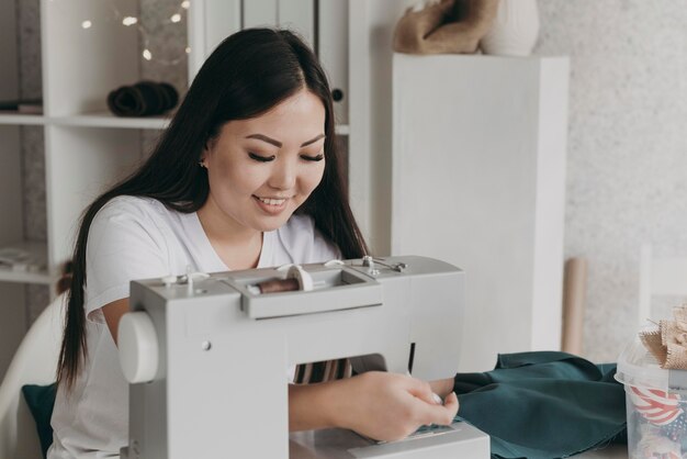 Medium shot smiley woman sewing