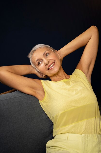 Foto gratuita donna sorridente di colpo medio che si siede sulla sedia