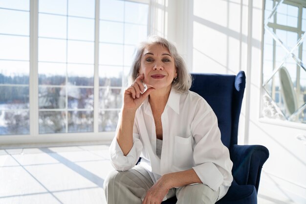 Medium shot smiley woman sitting on chair