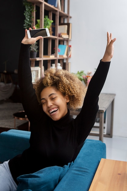 Free photo medium shot smiley woman sitting on couch