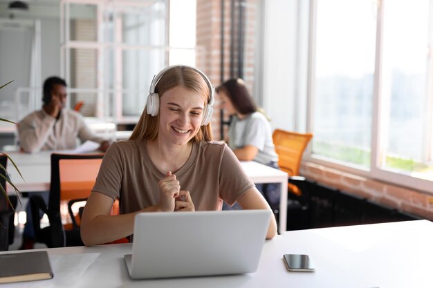 Medium shot smiley woman sitting at desk