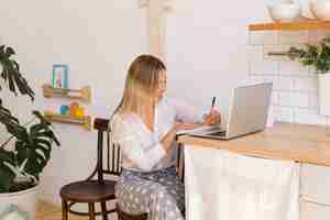 Free photo medium shot smiley woman taking notes