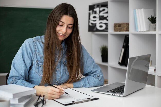 Medium shot smiley woman taking notes