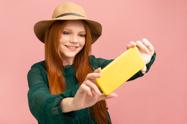 Foto gratuita donna di smiley del colpo medio che prende selfie