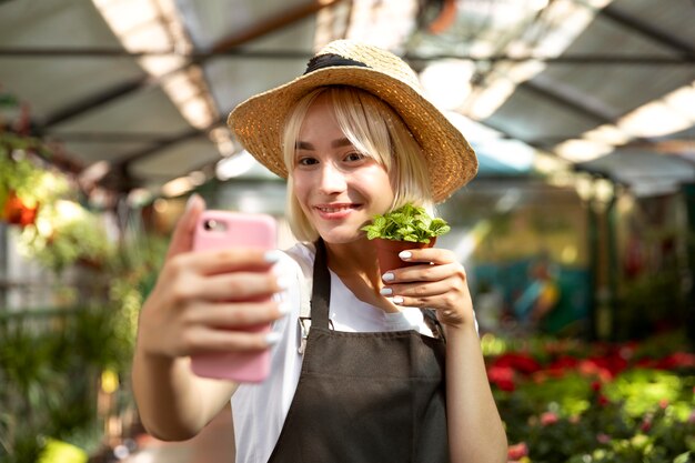 自撮り写真を撮るミディアムショットのスマイリー女性