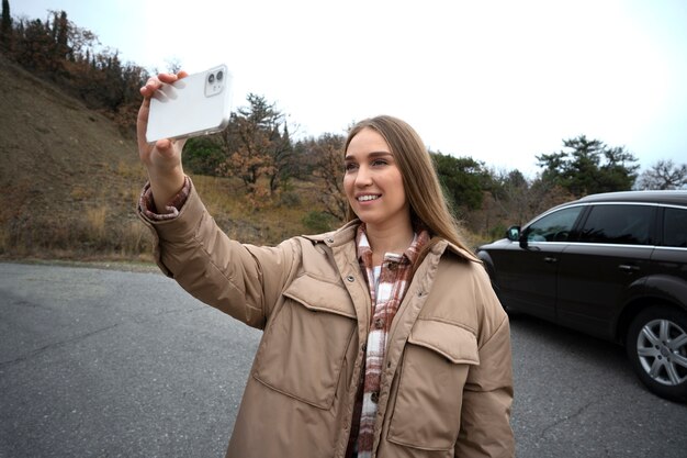 Medium shot smiley woman taking selfie