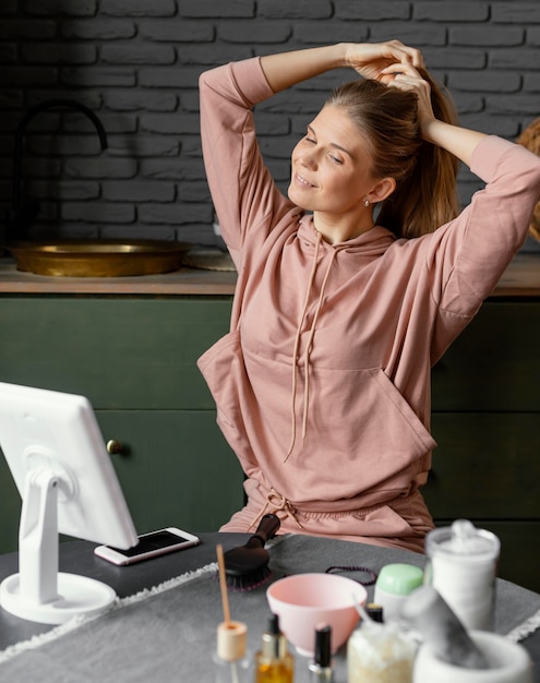 Medium shot smiley woman tying her hair