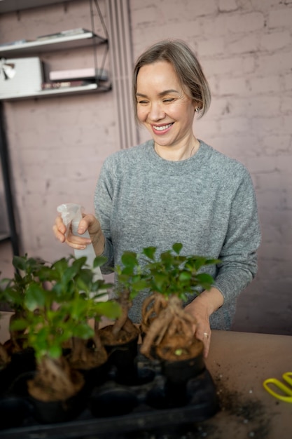 Medium shot smiley woman watering flowers