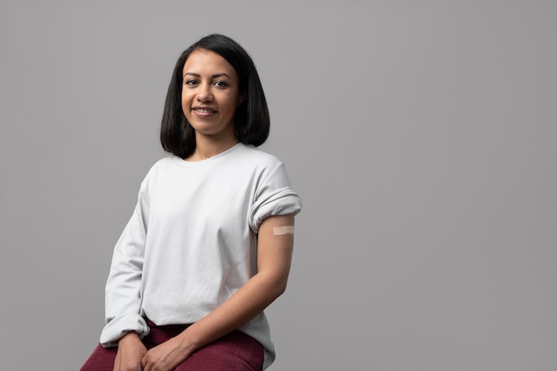 Free photo medium shot smiley woman wearing band aid