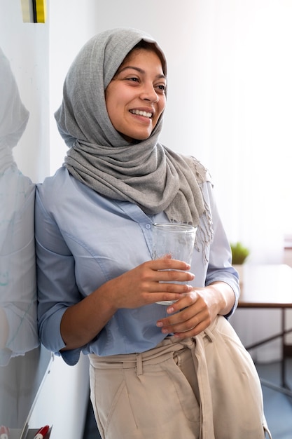 Donna sorridente con colpo medio che indossa l'hijab