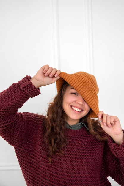 Foto gratuita donna sorridente del colpo medio che porta il cappello lavorato a maglia