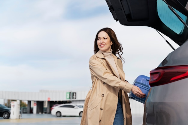 Medium shot smiley woman with baggage