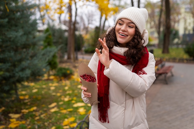 Free photo medium shot smiley woman with berries outside