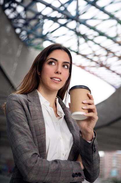 コーヒーカップとミディアムショットの笑顔の女性