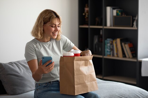 コーヒーカップを持つミディアムショットのスマイリー女性