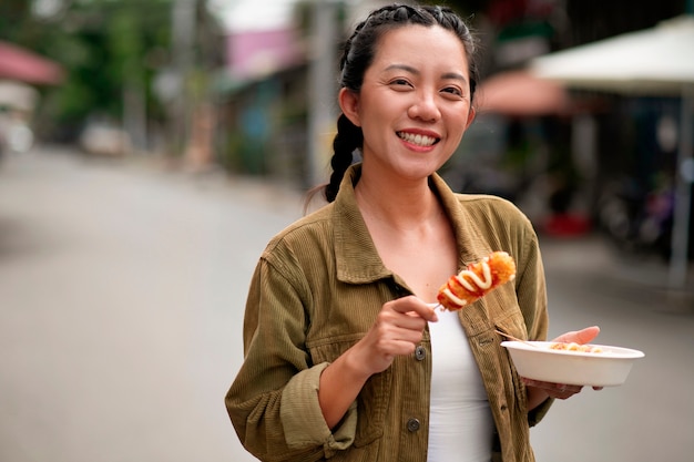 Medium shot smiley woman with corn dog