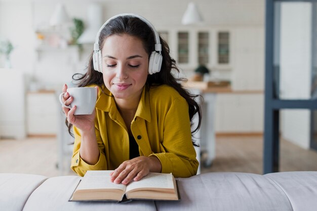 Medium shot smiley woman with cup and headphones