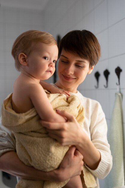 Medium shot smiley woman with cute baby