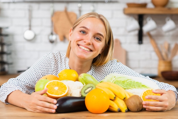 Medium shot smiley woman with delicious fruits