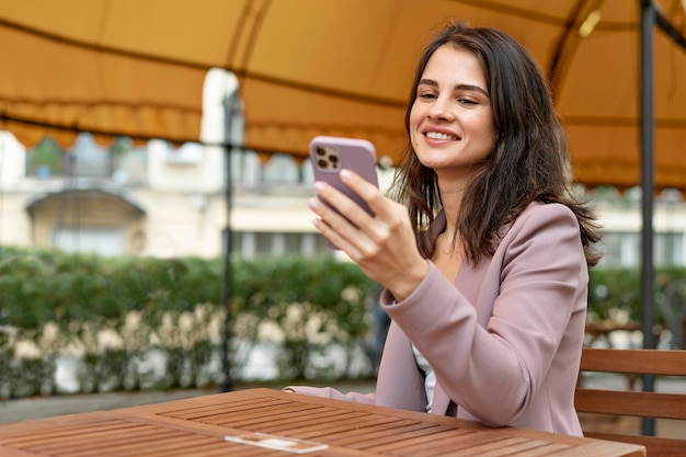 Medium shot smiley woman with device