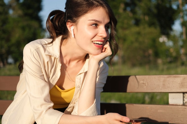 Foto gratuita donna sorridente a tiro medio con gli auricolari