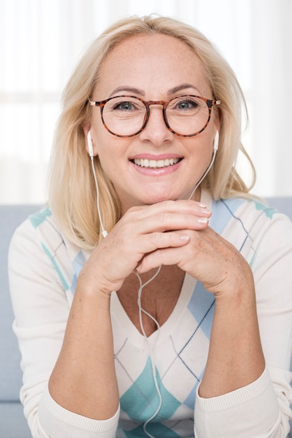 Medium shot smiley woman with glasses and headphones