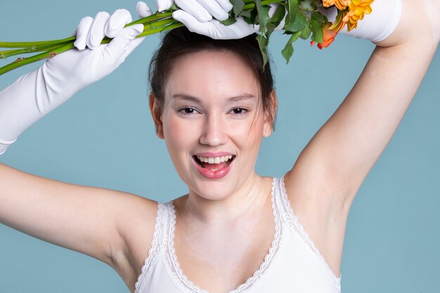 medium shot smiley woman with gloves and flowers