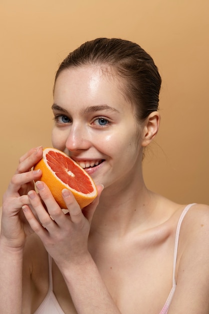 Medium shot smiley woman with grapefruit