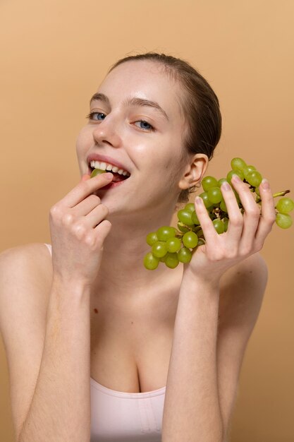 Medium shot smiley woman with grapes