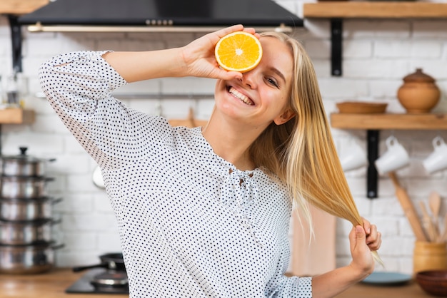 Free photo medium shot smiley woman with half orange