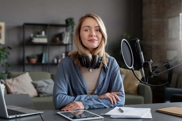 Medium shot smiley woman with headphones at studio