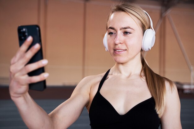 Medium shot smiley woman with headphones