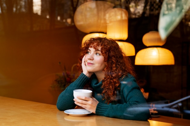 Donna sorridente del colpo medio con cioccolata calda