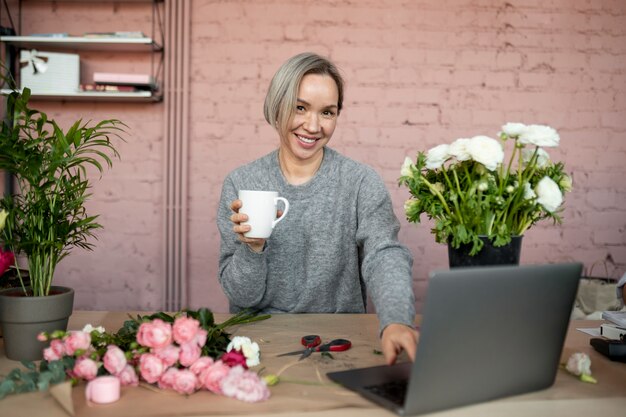 Medium shot smiley woman with laptop