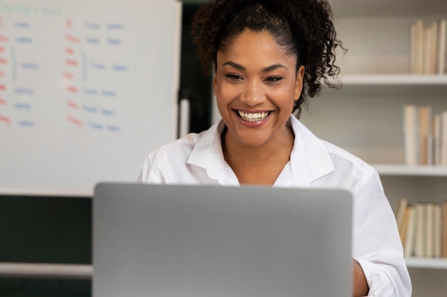 Medium shot smiley woman with laptop