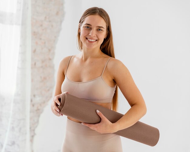 Medium shot smiley woman with mat