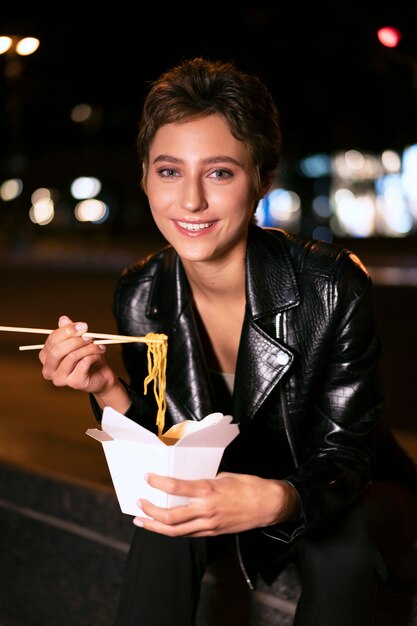 Medium shot smiley woman with noodles