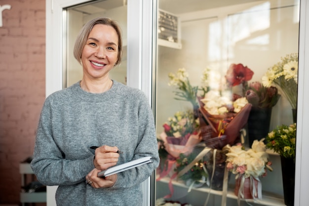 Medium shot smiley woman with notebook