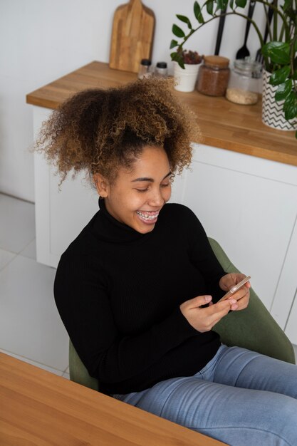 電話でミディアムショットのスマイリー女性