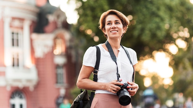 Free photo medium shot smiley woman with photo camera