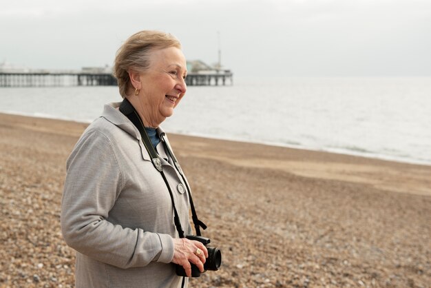 Medium shot smiley woman with photo camera