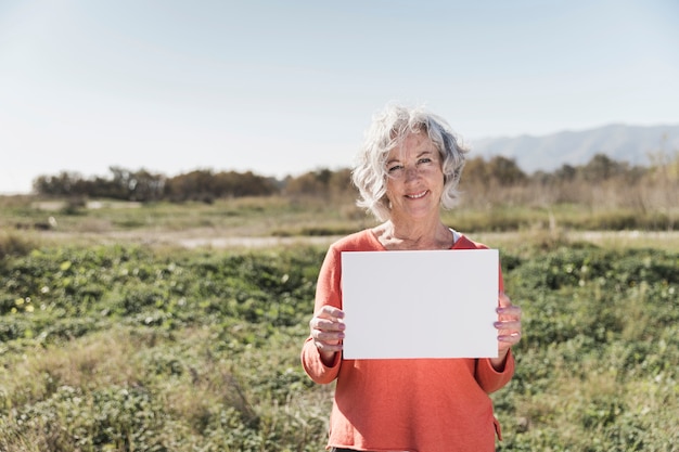 Medium shot smiley woman with piece of paper