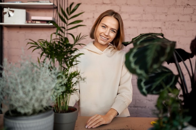 무료 사진 식물과 중간 샷 웃는 여자