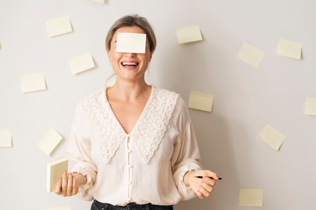 Foto gratuita donna sorridente del colpo medio con post-it