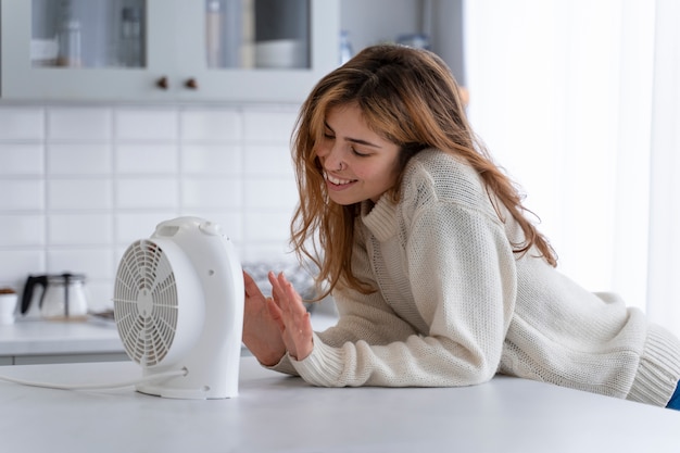 Medium shot smiley woman with small heater